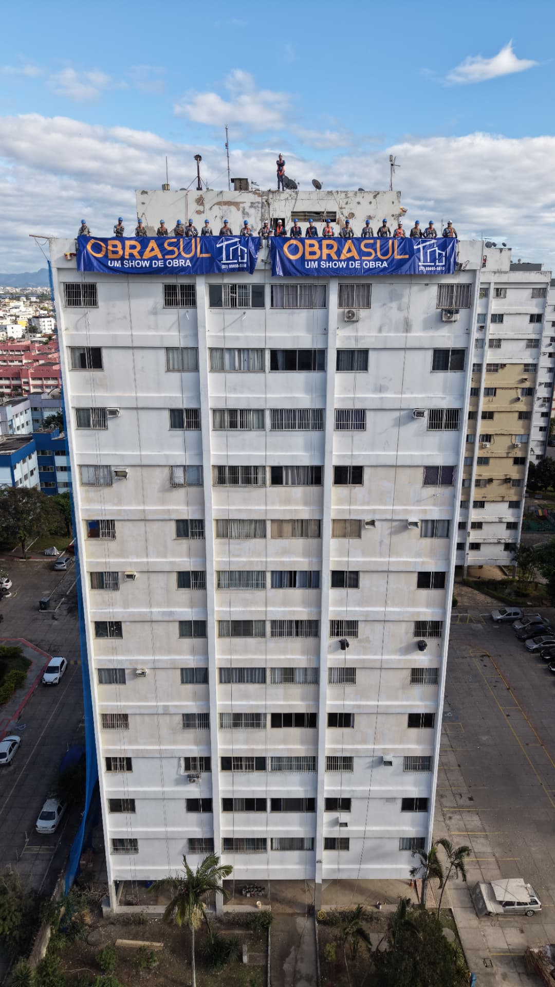 Equipe Obrasul no topo de um edifício com a bandeira Obrasul — Um show de obra